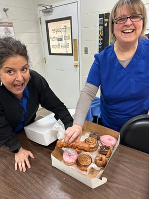 Staff with a box of donuts in a common area