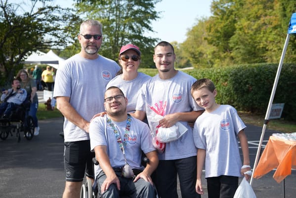 Five people smiling at an outdoor event