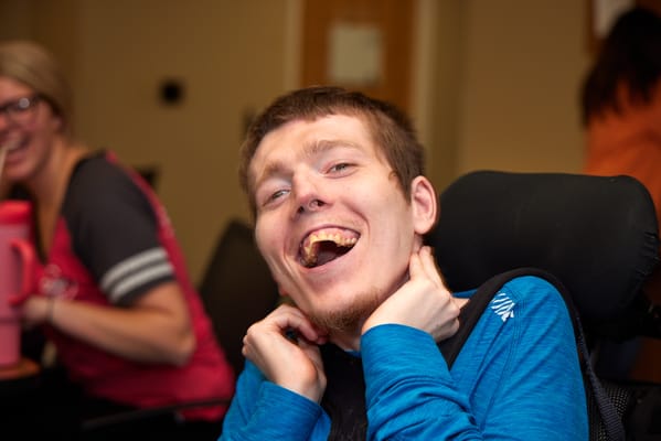 A resident smiling happily in a vibrant common area