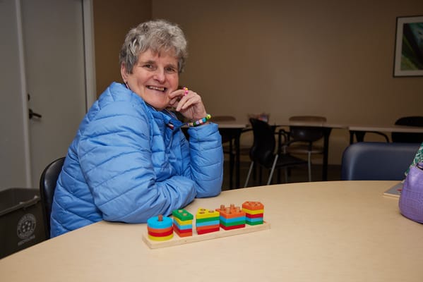 A cheerful resident playing with colorful stacking toys