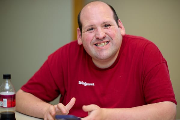 Smiling man at a table with a drink