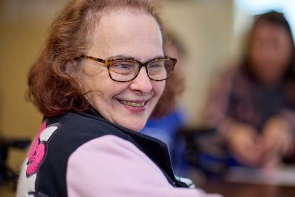 Smiling resident with glasses in a cozy setting