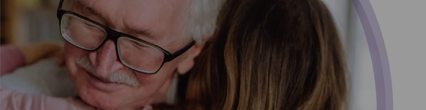 A senior man embracing a young woman