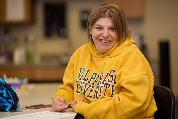 Resident smiling while working on a craft activity