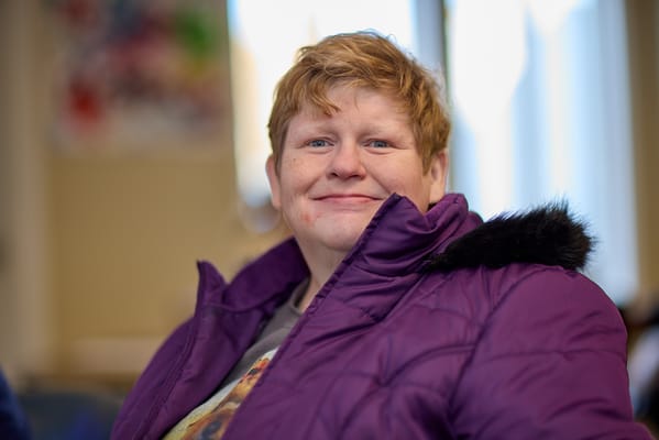 A resident smiling in a cozy interior setting