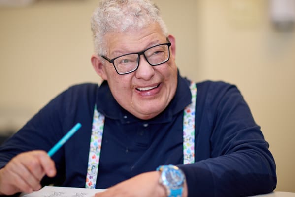 A smiling resident engaging in an activity indoors