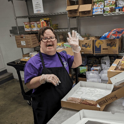 Staff member serving food in a kitchen setting