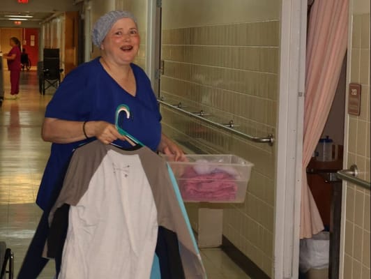 Staff member carrying laundry in the facility hallway