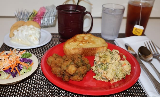 A plated meal with salad, fried okra, and dessert
