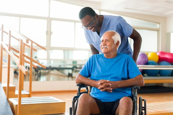 Staff assisting a resident in a rehabilitation setting