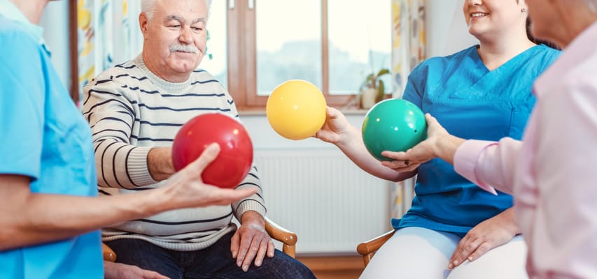 Residents and staff engaging in a recreational activity with colored balls