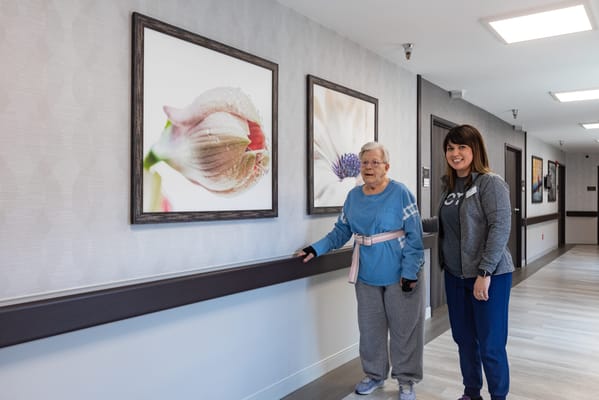 Residents enjoying a decorated hallway with floral art