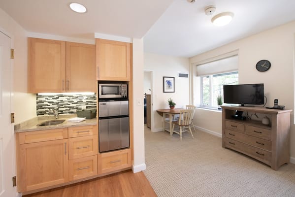 A cozy resident room with kitchenette and table