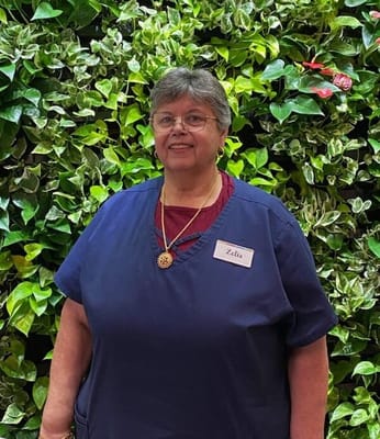 Staff member posing in front of a green wall