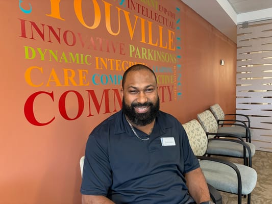 Staff member smiling in a colorful lobby area