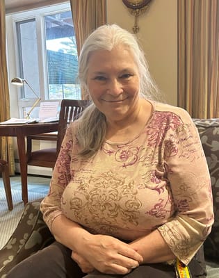 A resident smiling in a cozy interior setting