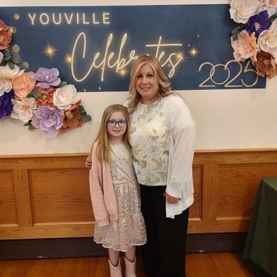 Two women posing at a celebratory event with decorations
