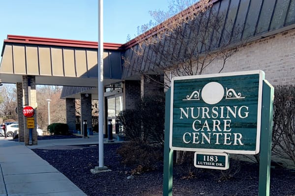 Exterior view of a nursing care center with signage