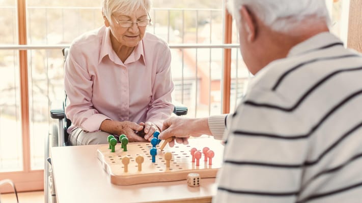 Residents playing a board game in an activity room