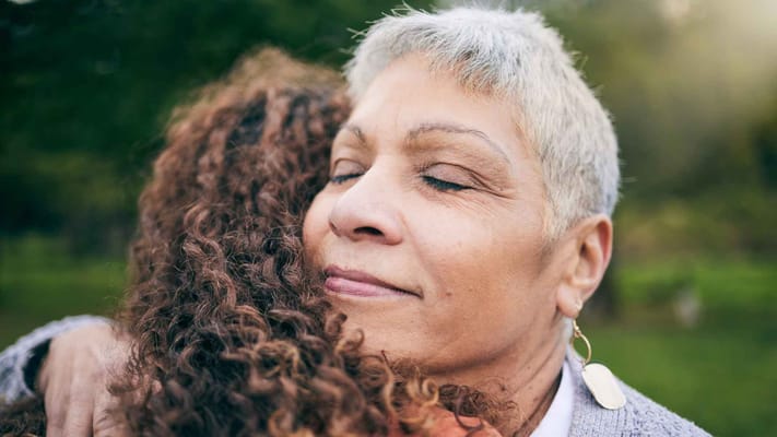 Two women embracing in a natural outdoor setting