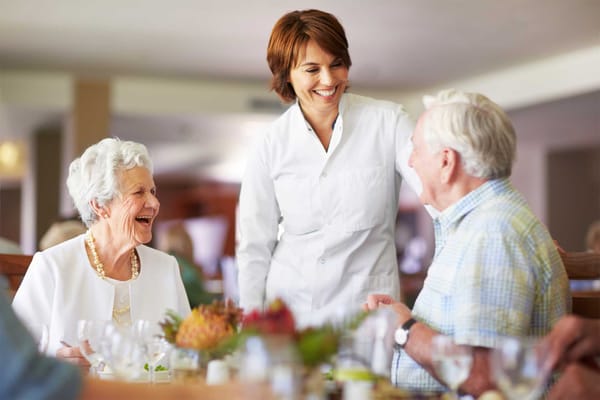 Staff serving residents in a dining room