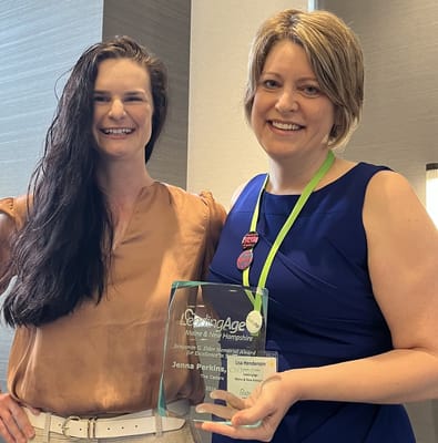 Two women holding an award at a recognition event