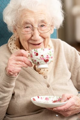 Elderly woman enjoying tea in a cozy setting