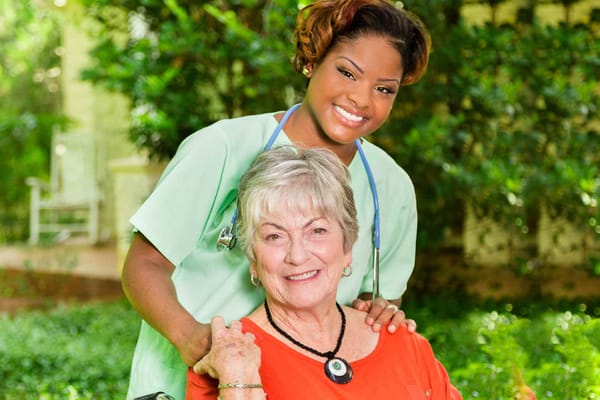 A caregiver with a senior resident in a garden
