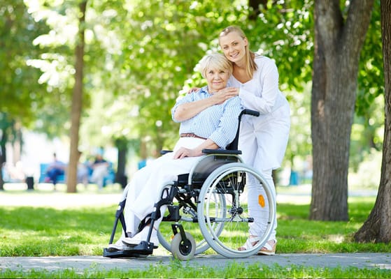 Caregiver and resident smiling in a sunny outdoor space