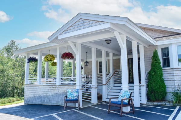 Front entrance of a senior care facility with hanging flowers