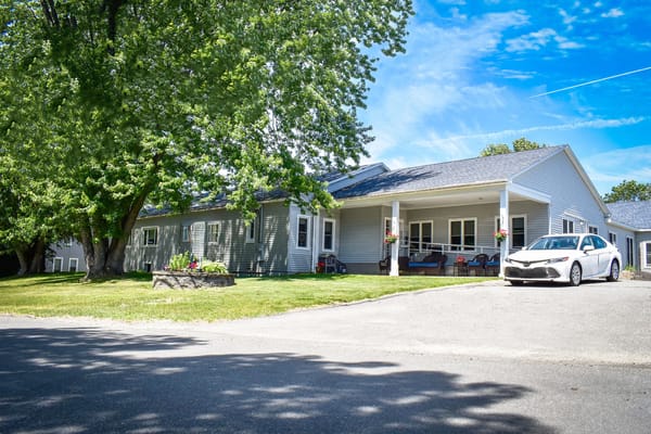 Exterior view of the facility with a car and garden