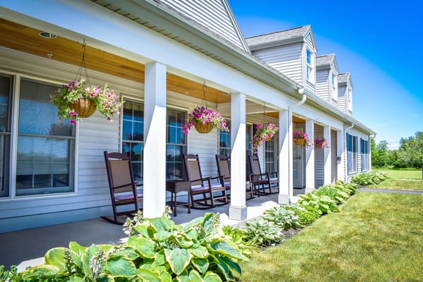 Outdoor seating area with hanging plants and rocking chairs
