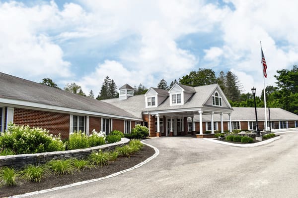 Exterior view of a senior living facility with gardens