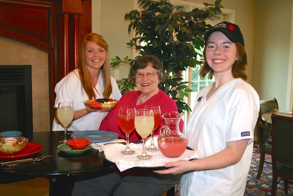 Staff serving refreshments to a resident in the dining room
