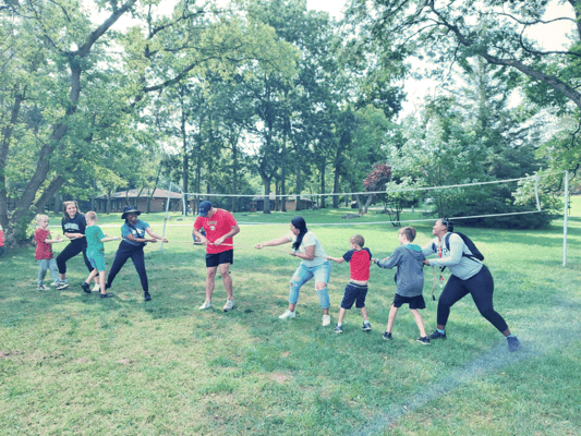 Residents and staff enjoying a tug of war in a park