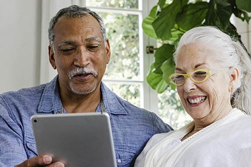 Two residents joyfully interacting with a tablet