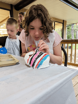 Child painting a craft project outdoors