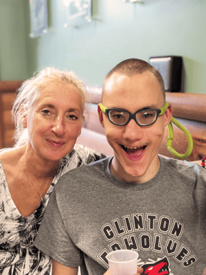 A woman and a young man smiling together in a cozy space