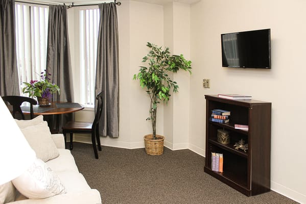 Cozy resident room with furnishings and a TV