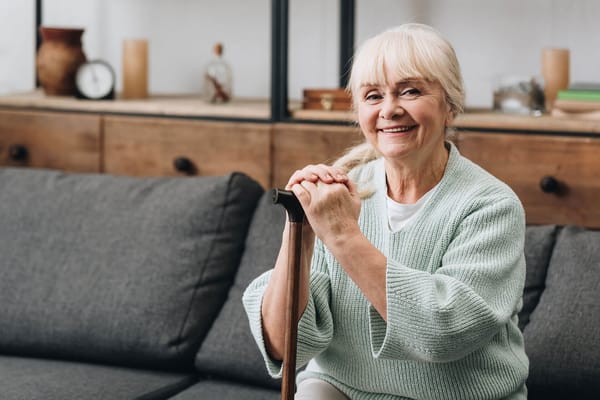 Senior resident smiling while sitting on a couch