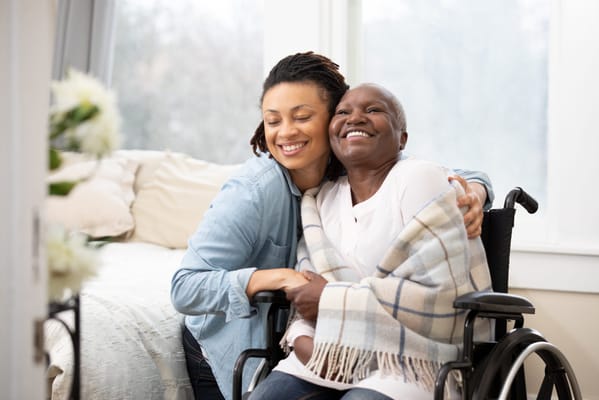 A caregiver and resident sharing a joyful moment in a room