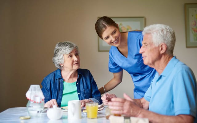 Residents enjoying a meal with a caregiver