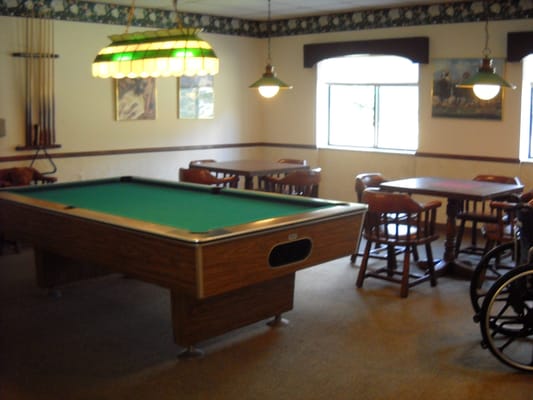 Interior game room with a pool table and seating