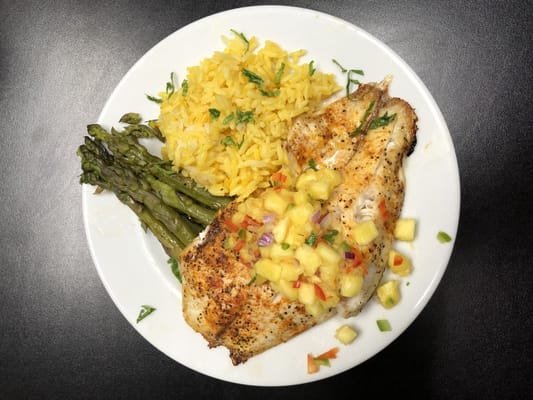 A dish of grilled fish with rice and asparagus