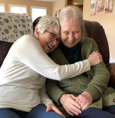 Two residents sharing a joyful moment in a common area