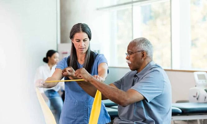 Staff assisting a resident with therapy exercises