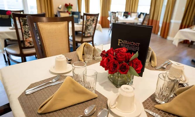 A beautifully set dining table with roses in a senior living facility