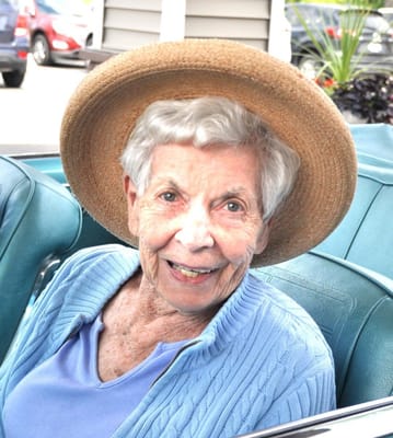 Senior resident smiling in a sunny outdoor setting