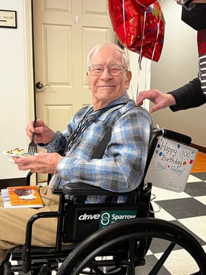 Resident celebrating 100th birthday with dessert