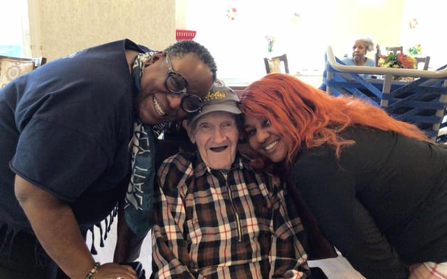 Staff and resident smiling together in a common area